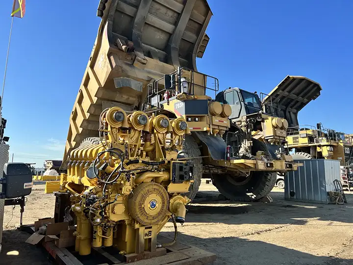 Remanufactured CAT engine staged beside a CAT mining haul truck during on-site field support.